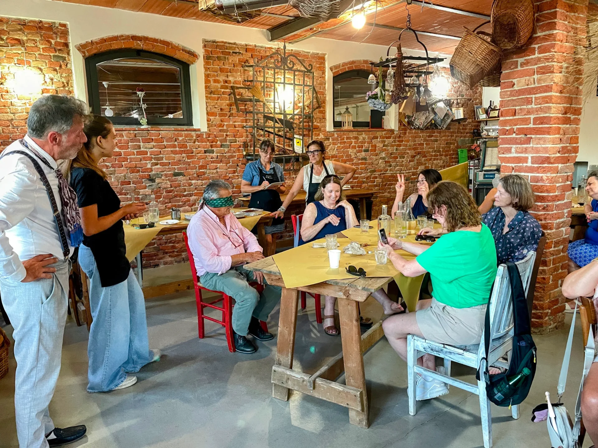 Man with a blindfold sitting and women surrounding him on a women only group tour