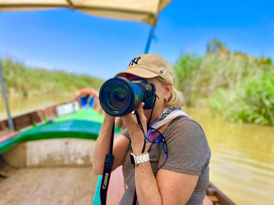 woman with camera taking pictures in a boat